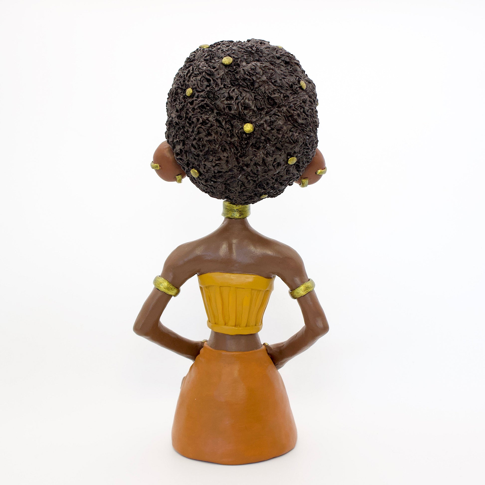 A polymer clay sculpture of the Leo zodiac personified as a woman, featuring yellow, orange and gold tones, and a mane-like afro hairstyle.